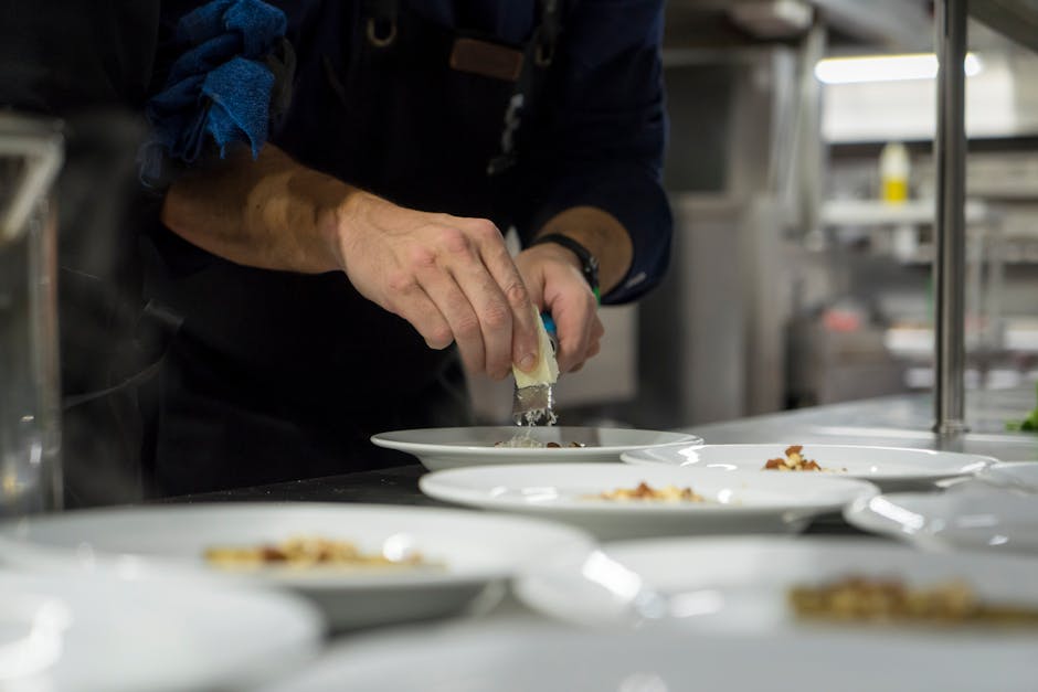 Chef che impiatta con cura un piatto di alta gastronomia